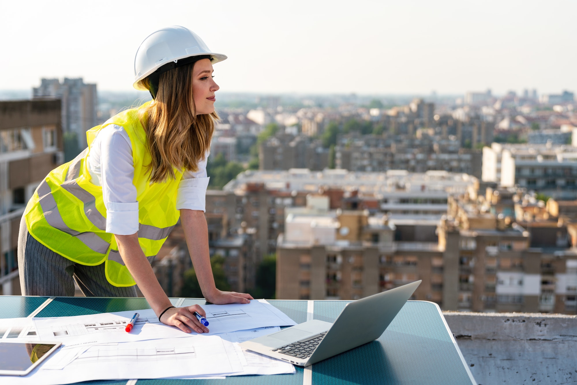 CONSTRUCTION AND RENOVATIONS: OPTIONS FOR UPGRADING YOUR HOME. Portrait of engineer businesswoman at construction site. Female architect with blueprint.